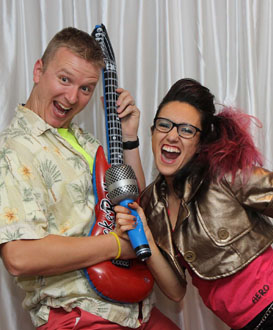 crazy funny couple posing with music props in front of a silver backdrop