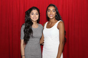 2 girls at a school event in front of a crimson red backdrop