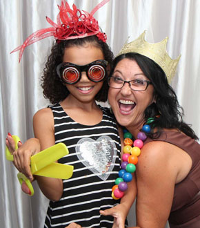 mother and daughter having fun in the photo booth with a white backdrop